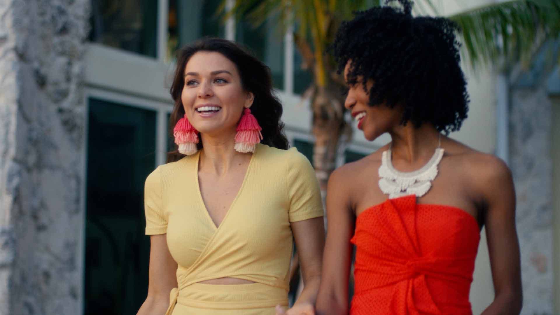 Two friends laughing in front of palm trees on the JW Marriott property