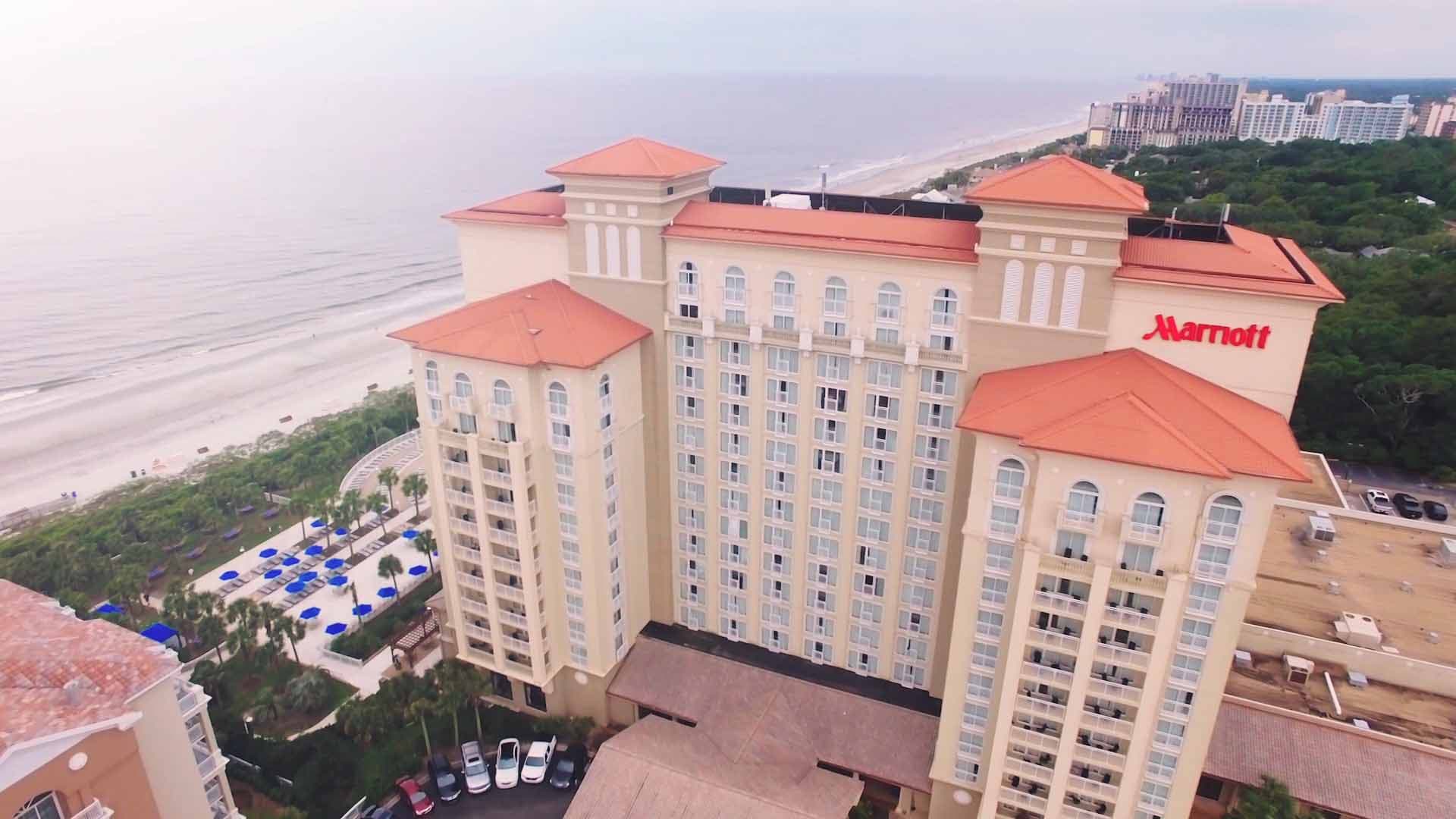 Aerial of the Myrtle Beach Marriott tower with red Marriott logo, beach in background