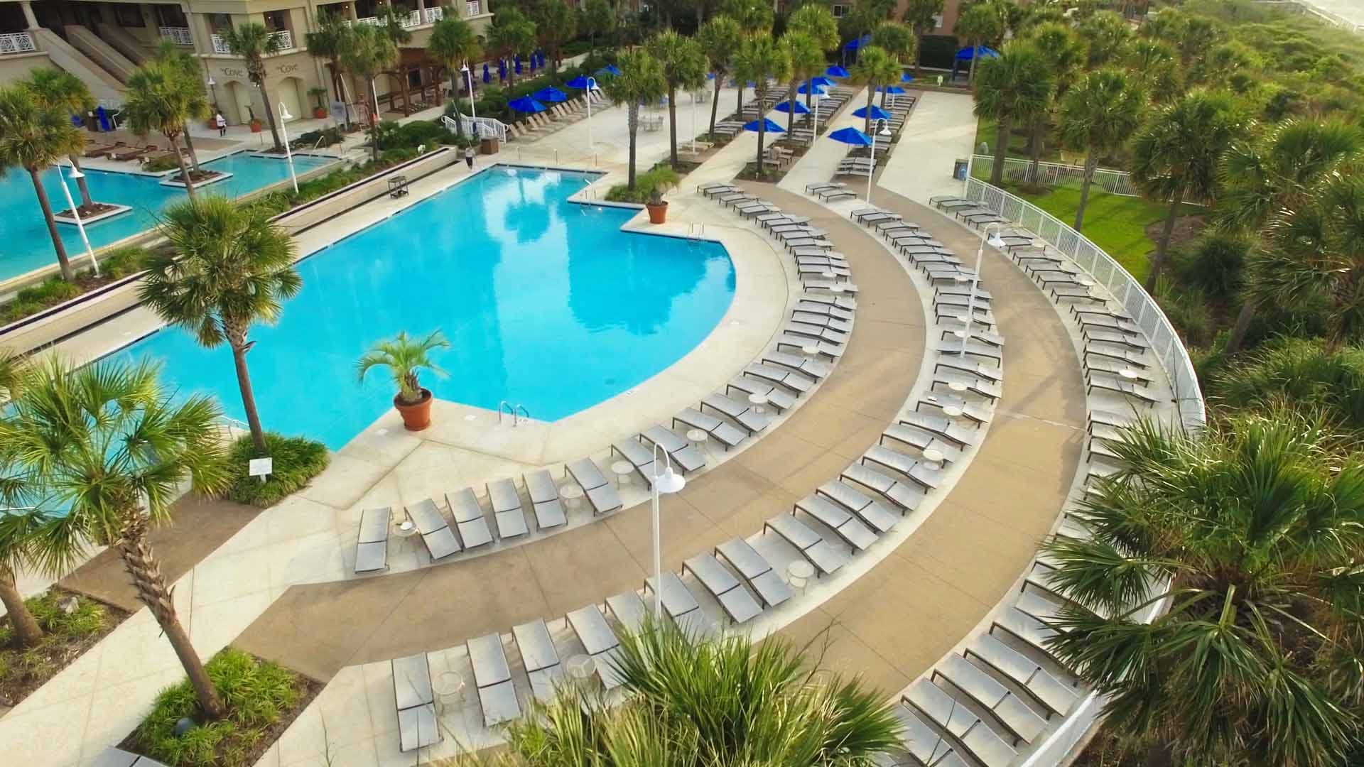 Drone aerial of the resort's curved pool deck and lounge layout